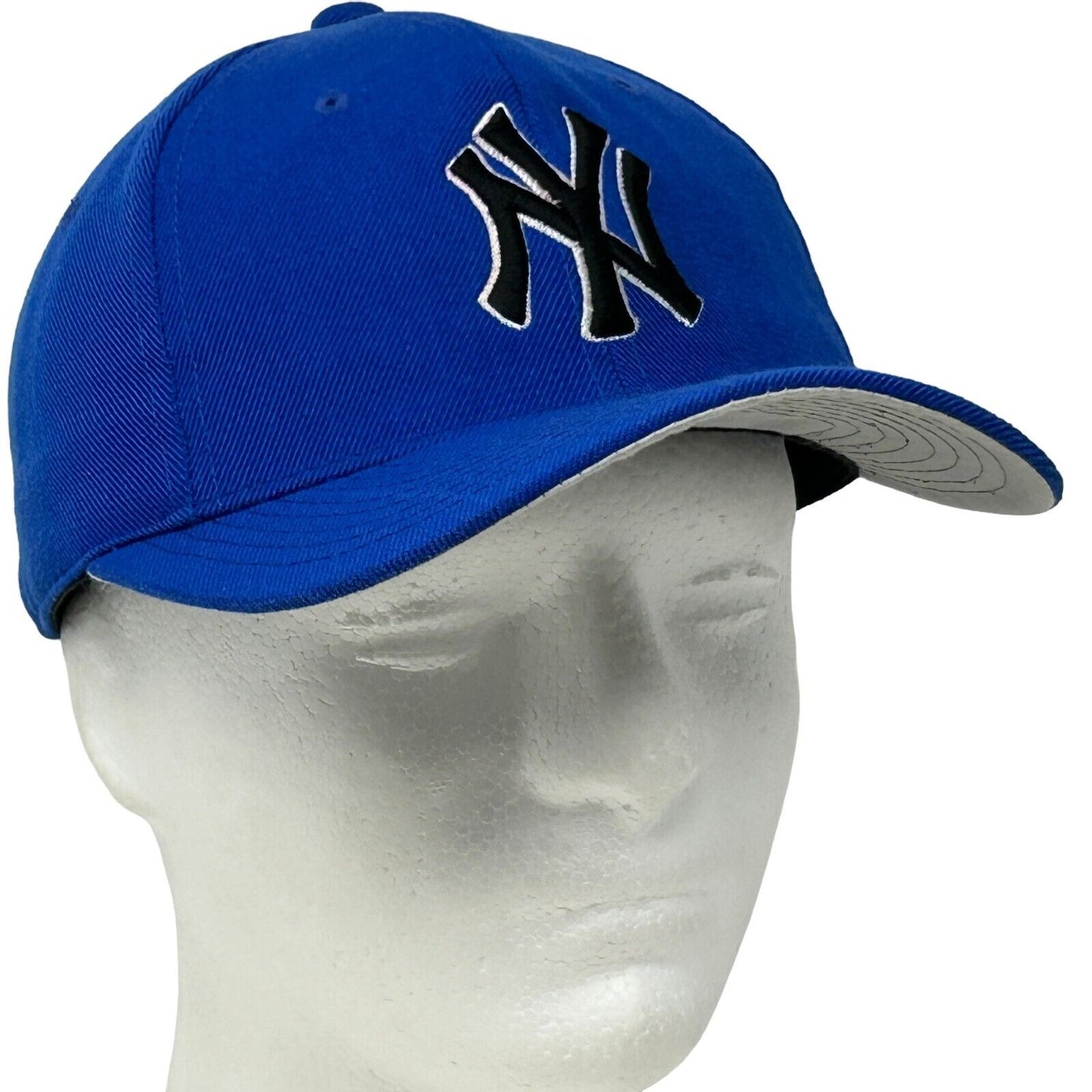 Blue New York Yankees baseball cap with raised logo on the front and gray underbill design