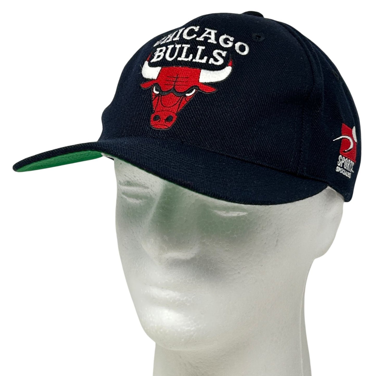 Front view of a black Chicago Bulls hat with embroidered logo and green brim