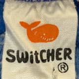 Close-up of a vintage Switcher t-shirt tag showcasing Switcher T-Shirt Tag History with logo and fabric details