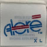 Detailed close-up of an Alore t-shirt tag showcasing the Alore T-Shirt Tag History from the 1990s