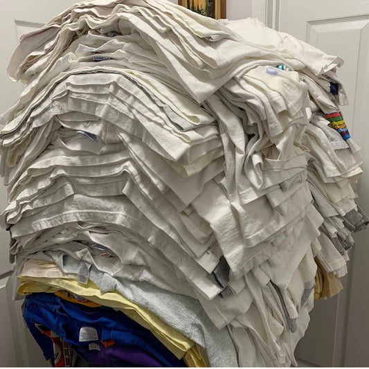 A large stack of white t-shirts ready to clean stained white t-shirts for reselling or personal use