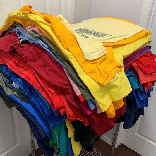 A vibrant stack of colored t-shirts ready for a guide on how to clean stained colored t-shirts