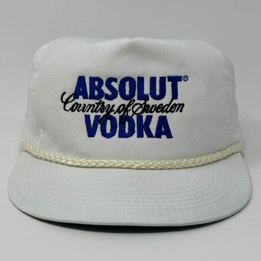 Front view of a white Absolut Vodka Hat with blue logo and woven trim, size adjustable for comfort