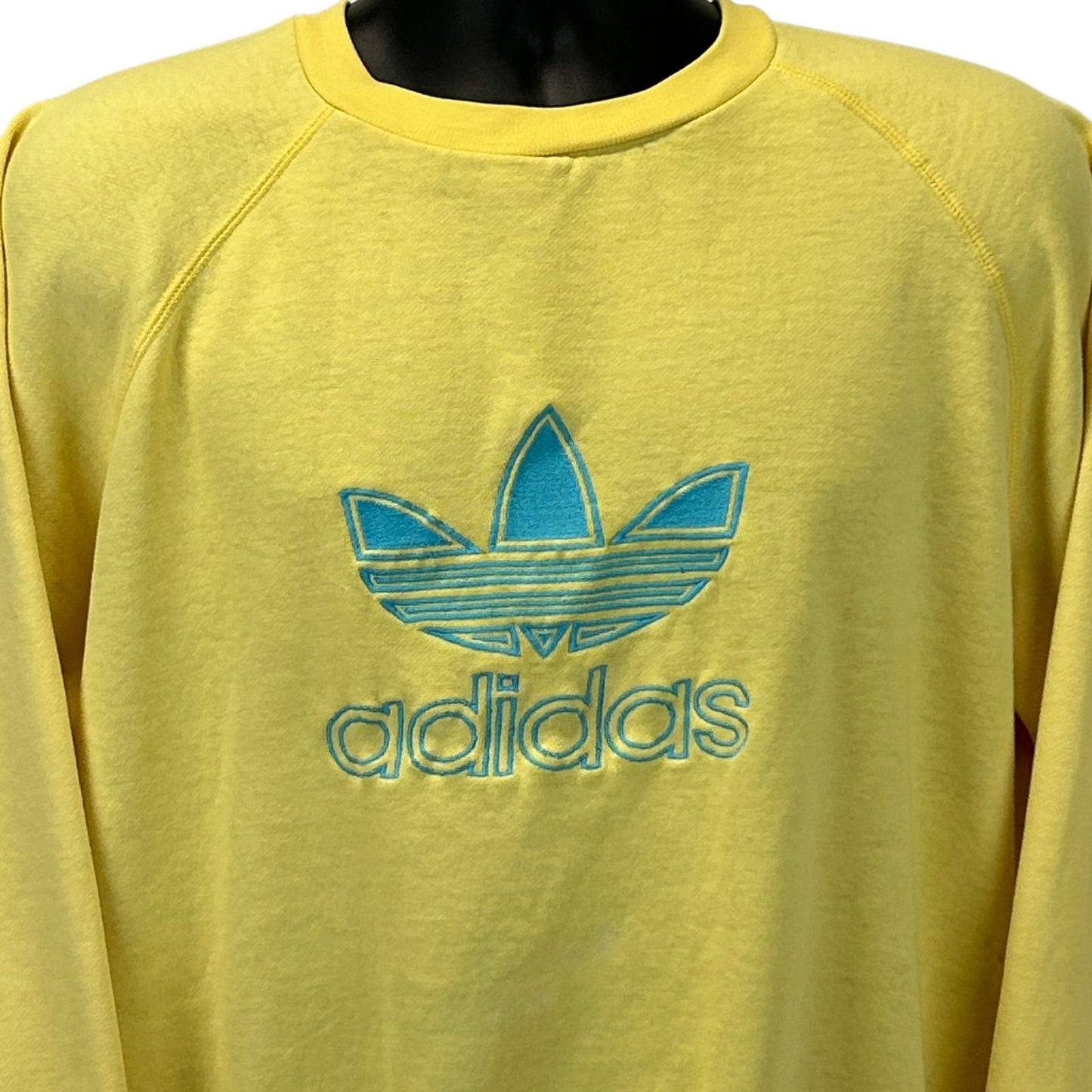 Front view of yellow Adidas Trefoil sweatshirt with embroidered blue logo on the chest