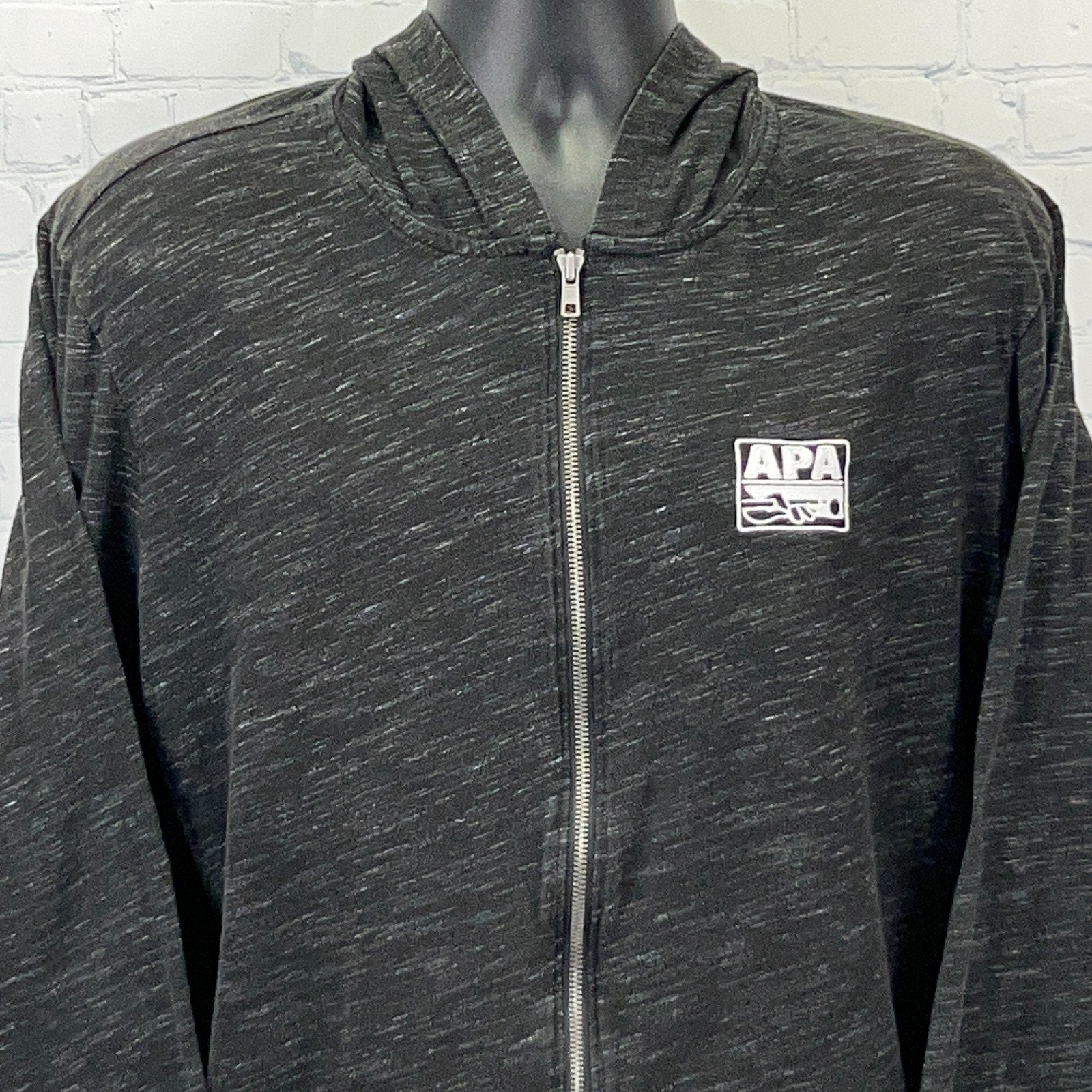 Black zip-up hoodie featuring APA logo, ideal for billiards enthusiasts, front view with detail of fabric