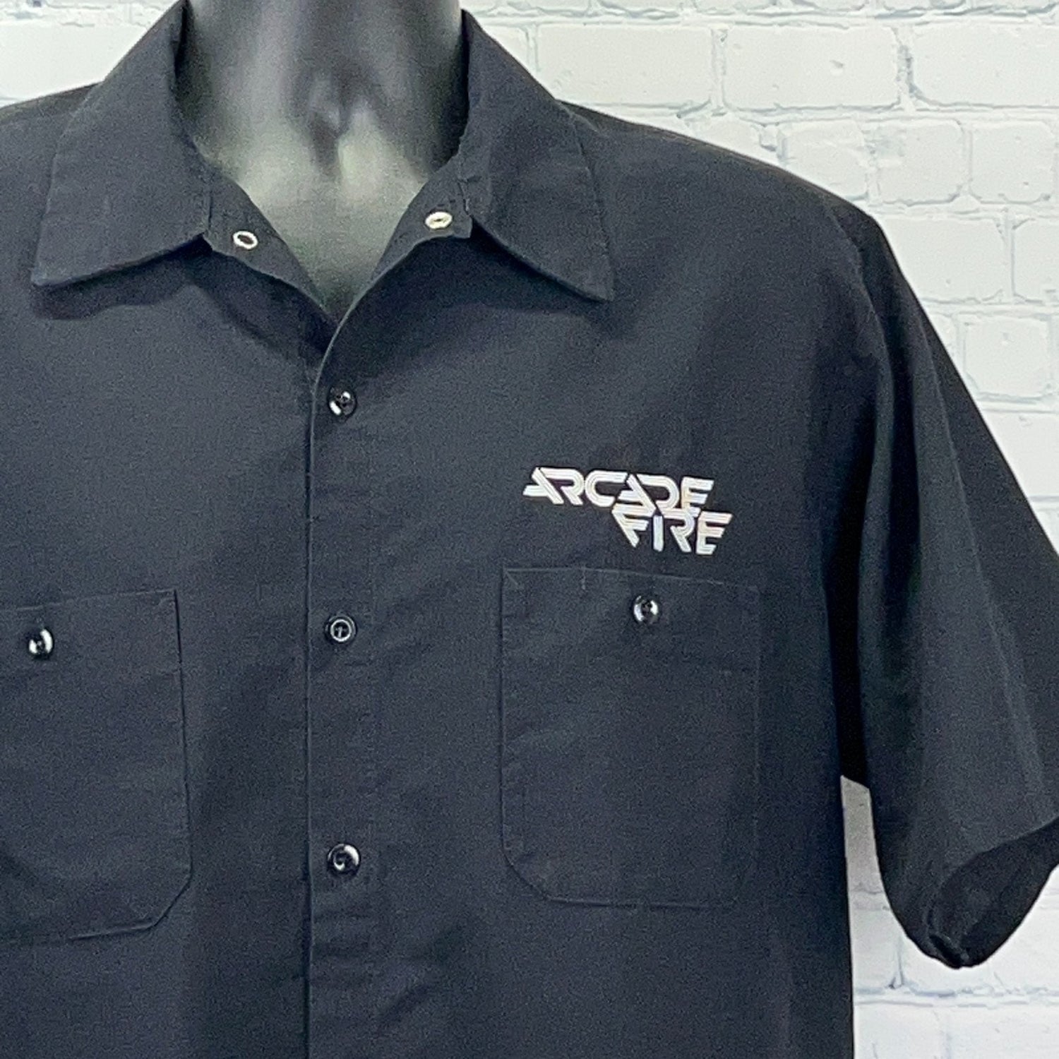 Black Arcade Fire Shirt featuring a front button closure and logo on the left chest pocket