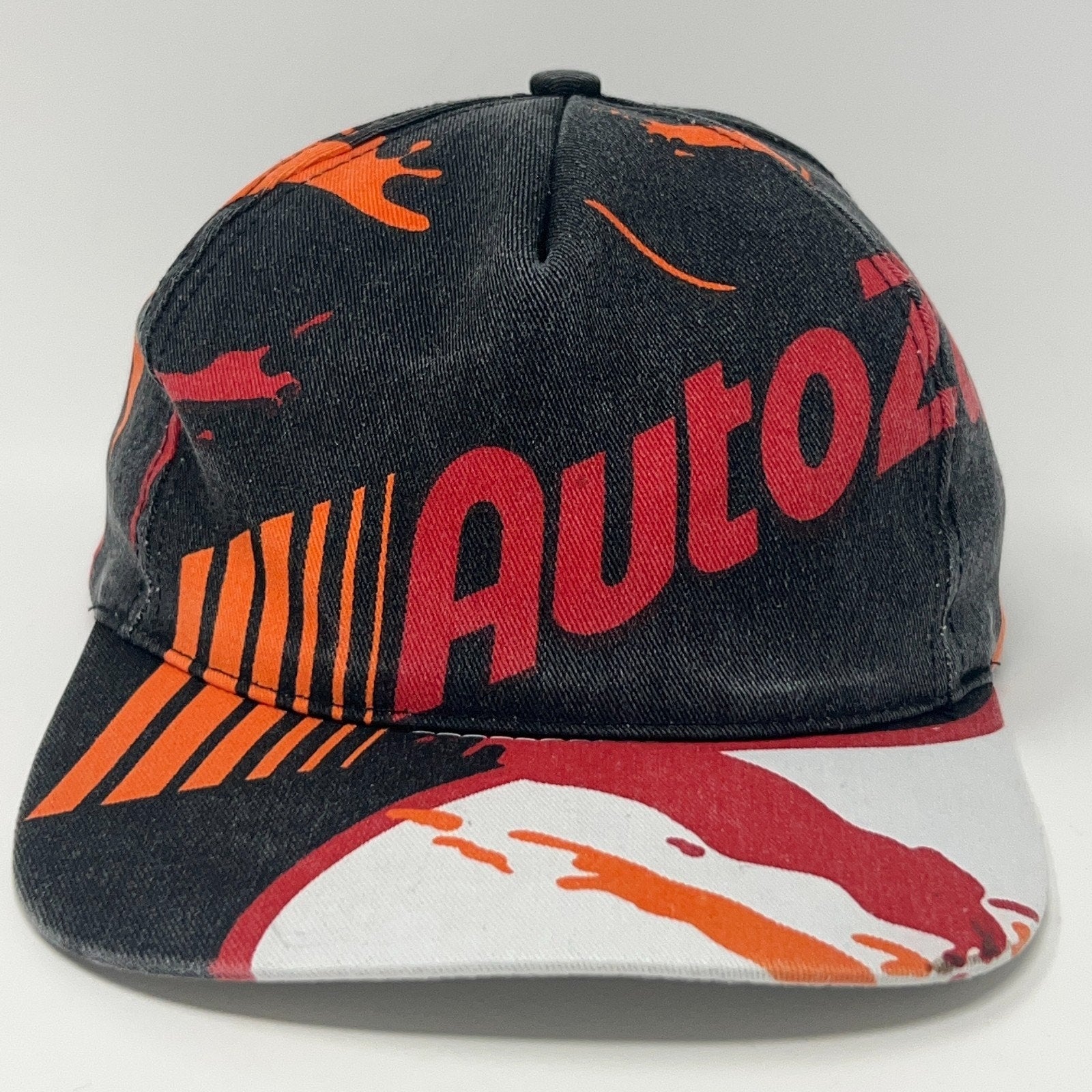 Front view of a Vintage AutoZone cap featuring a colorful splash design in black, red, and orange.