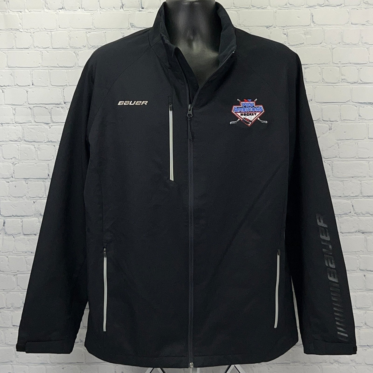 Bauer Pro Ambitions Hockey jacket in black, featuring logo and reflective details for visibility.