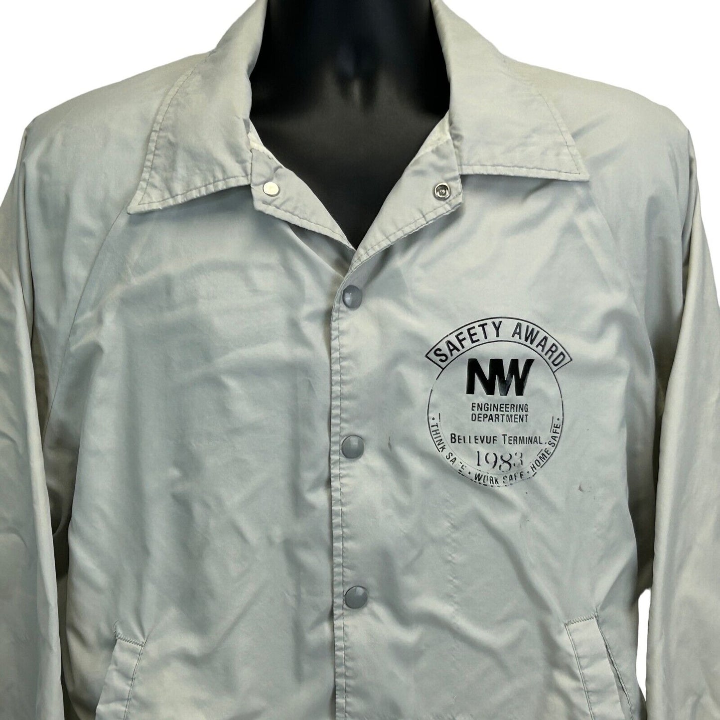 Vintage Bellevue Terminal Jacket in beige with front button closure and a safety award logo on the chest