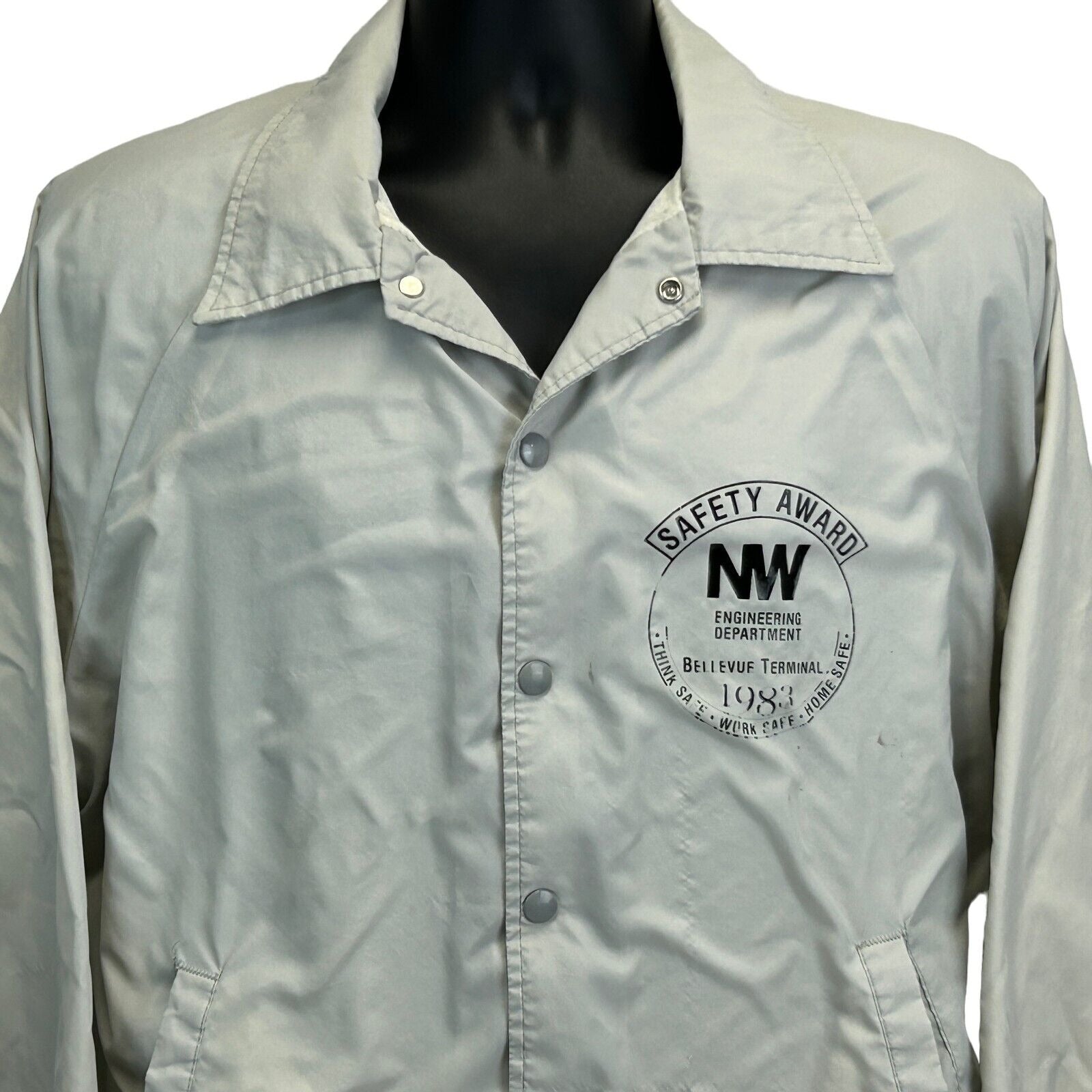 Vintage Bellevue Terminal Jacket in beige with front button closure and a safety award logo on the chest