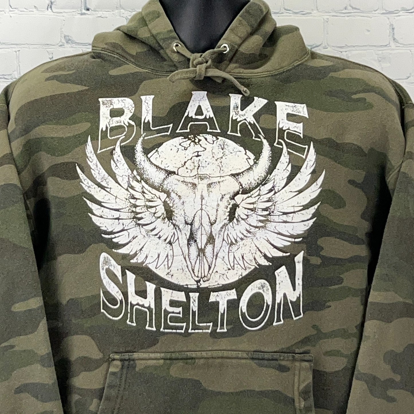 Olive camo hooded sweatshirt featuring Blake Shelton graphic with wings and skull design