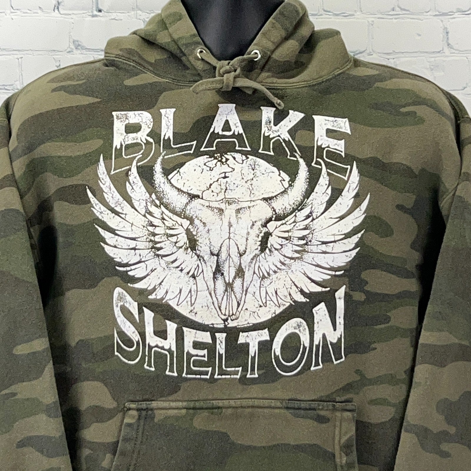 Olive camo hooded sweatshirt featuring Blake Shelton graphic with wings and skull design