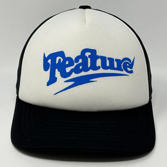White and black Feature hat with a bold blue logo on the front view