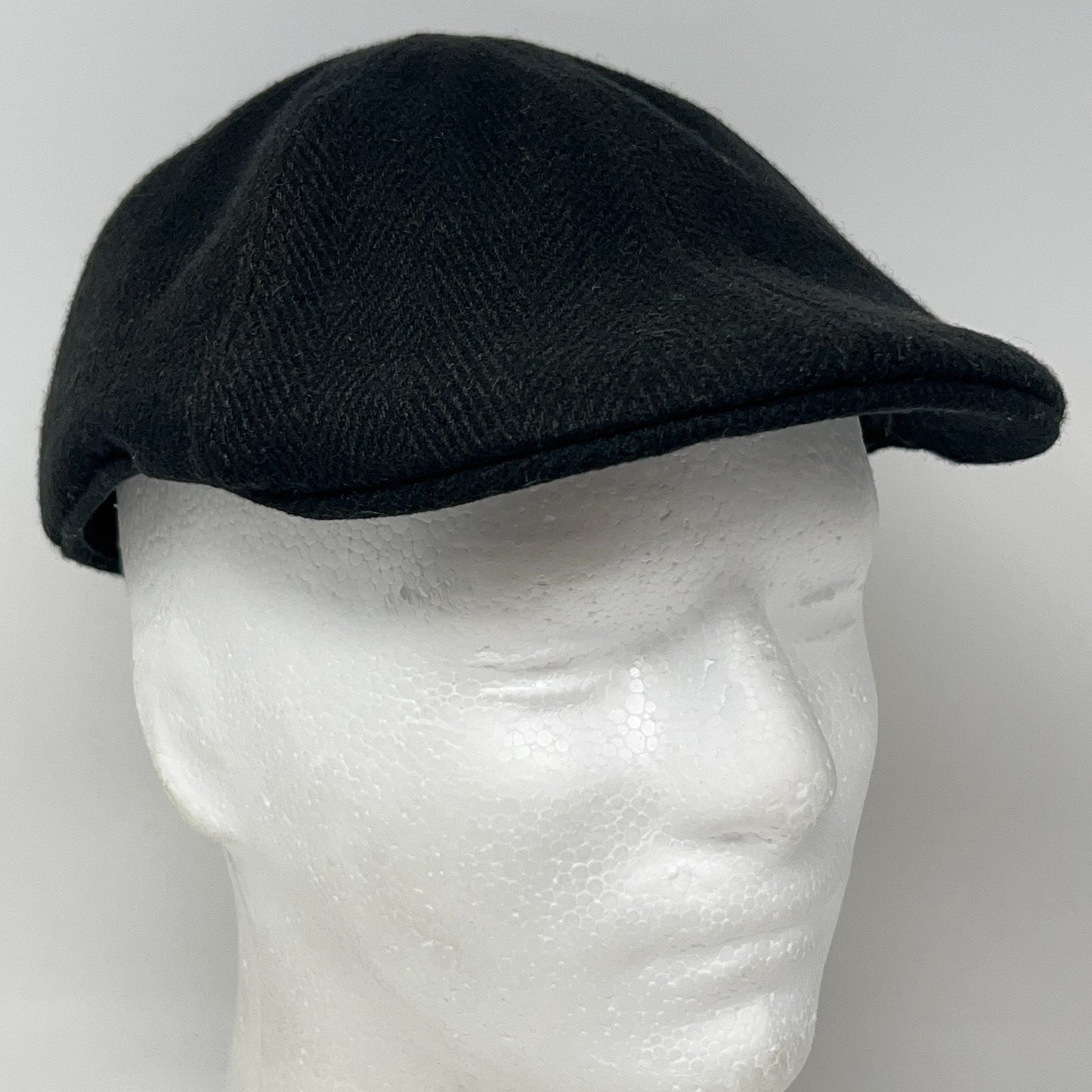 Black Flat Cap made from wool, side view showing a classic design and structured fit