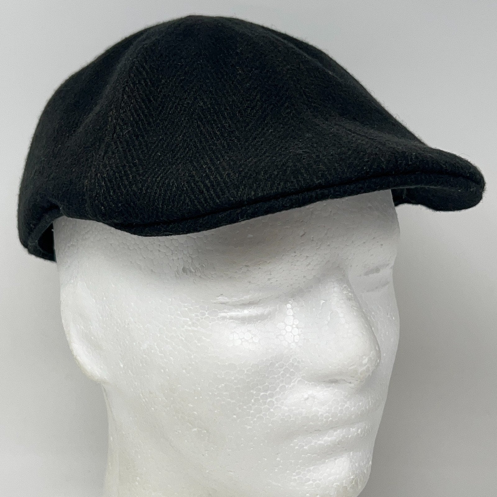 Black Flat Cap made from wool, side view showing a classic design and structured fit