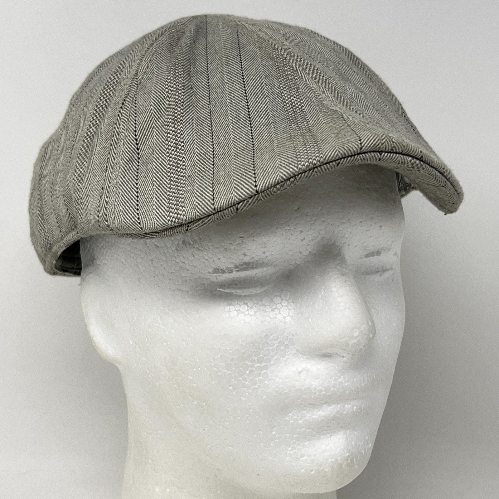 Vintage Stone Gray Flat Cap featuring herringbone pattern, viewed from the front on mannequin head