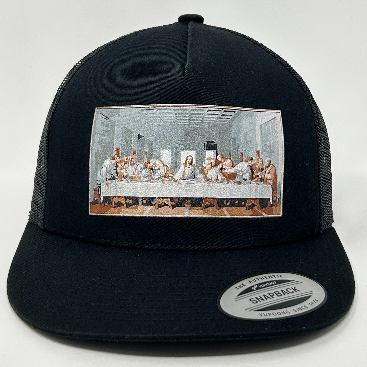 Black Yupoong snapback hat featuring The Last Supper graphic on the front in detailed color