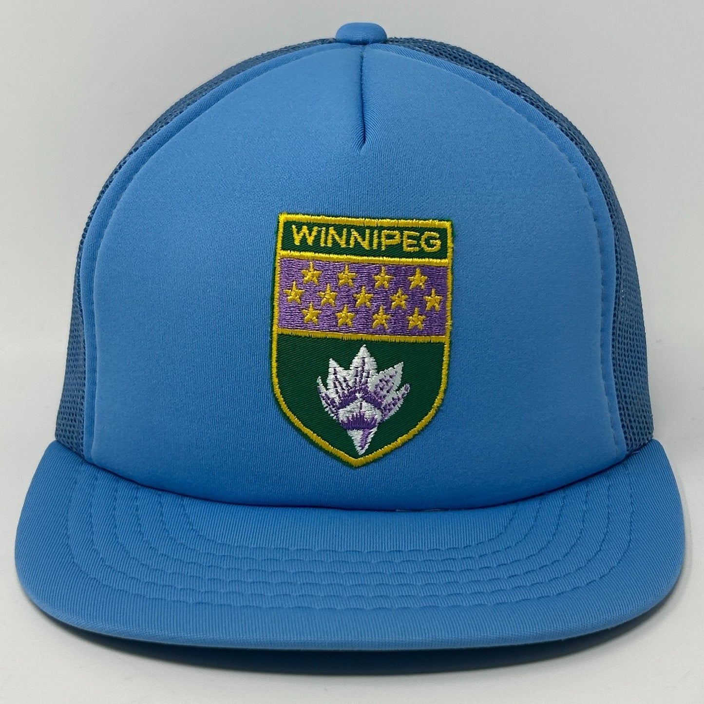 Front view of blue Winnipeg Hat featuring embroidered badge and mesh back for comfort