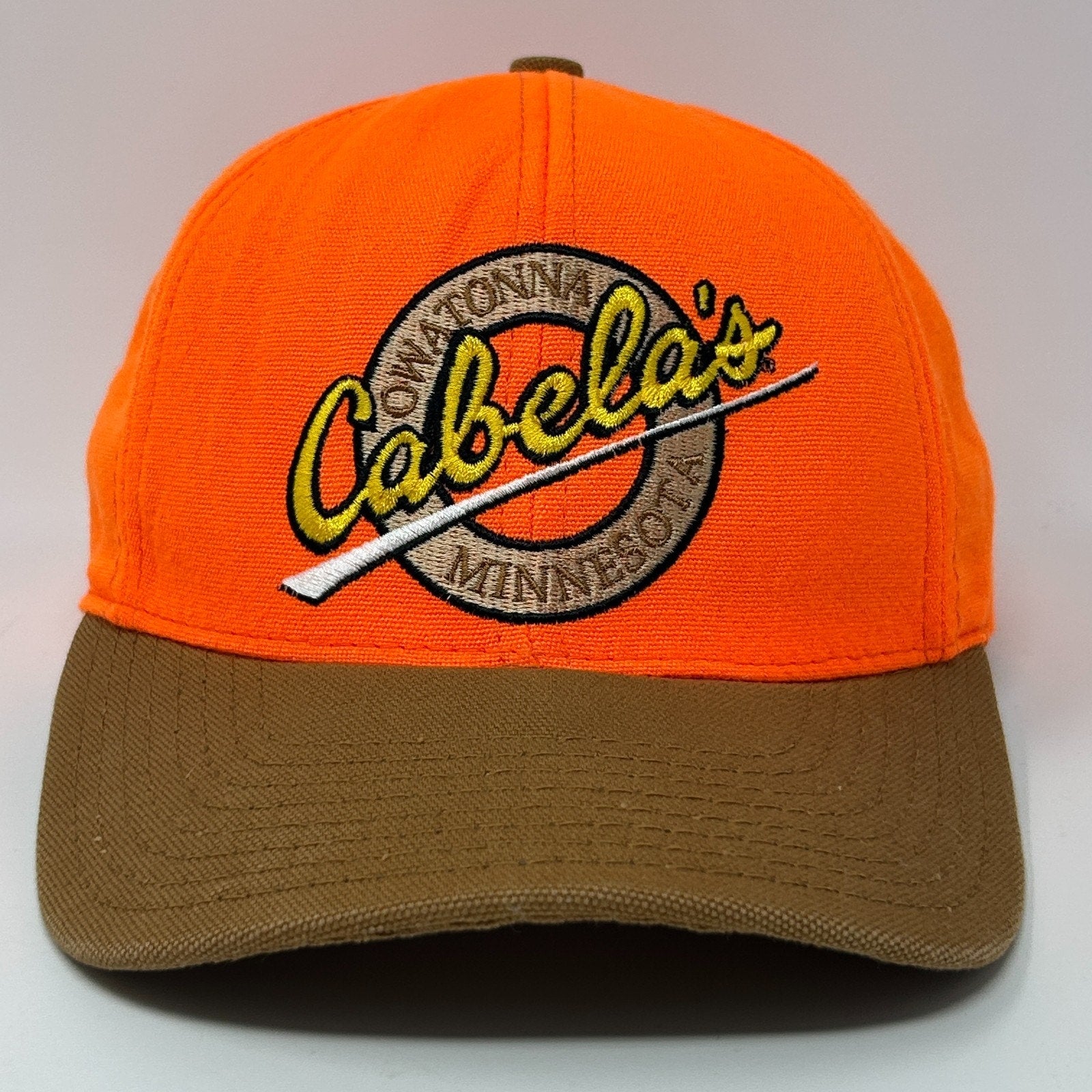 Front view of an orange Cabelas Hat with brown brim and embroidered logo on the front