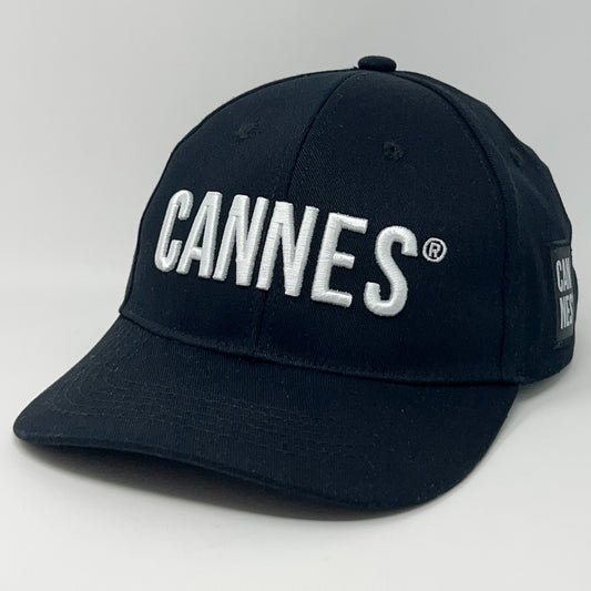 Black Cannes Hat with white embroidered logo, structured front, and adjustable strap at the back