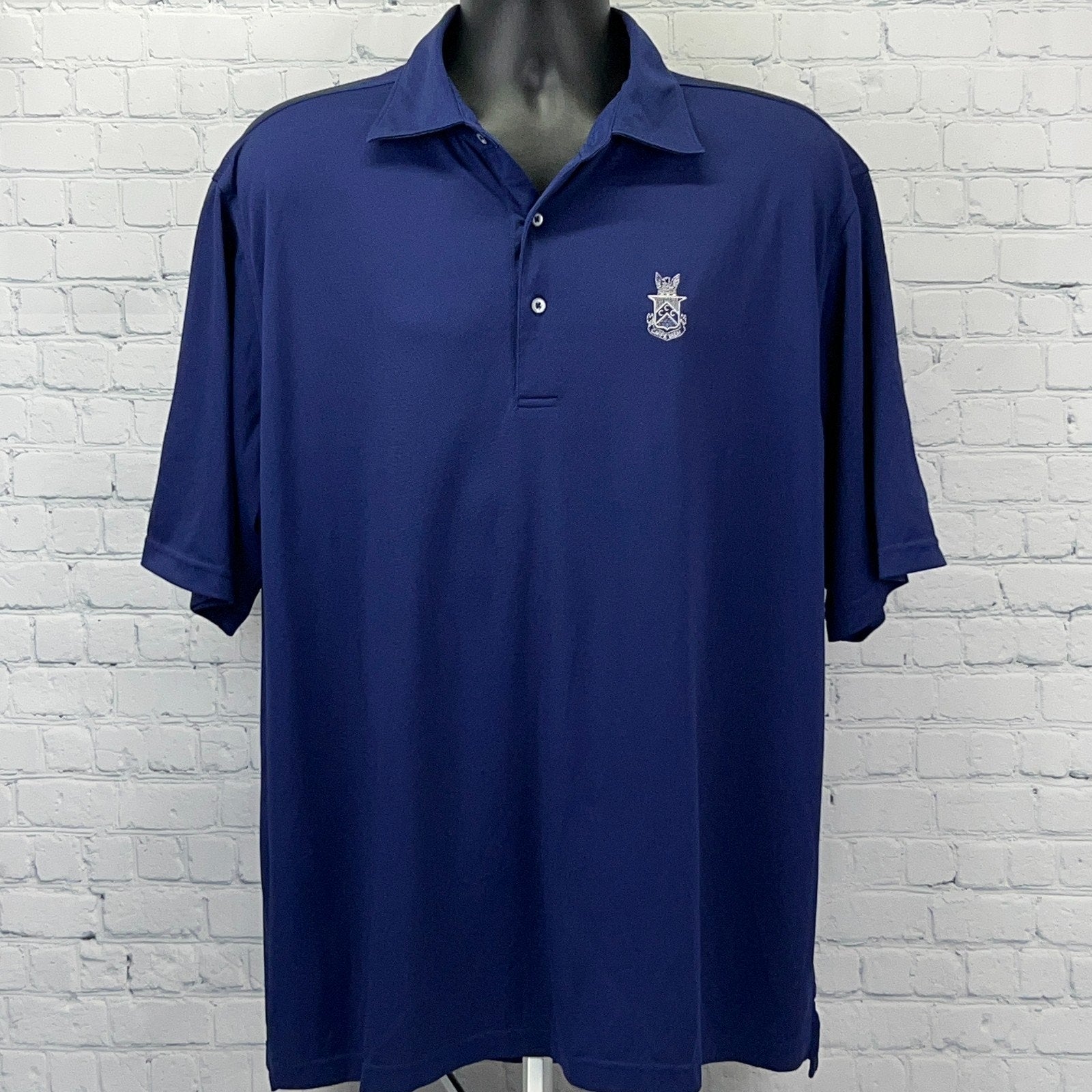 Navy blue polo shirt with a front logo of Capital City Club, featuring a relaxed fit and short sleeves