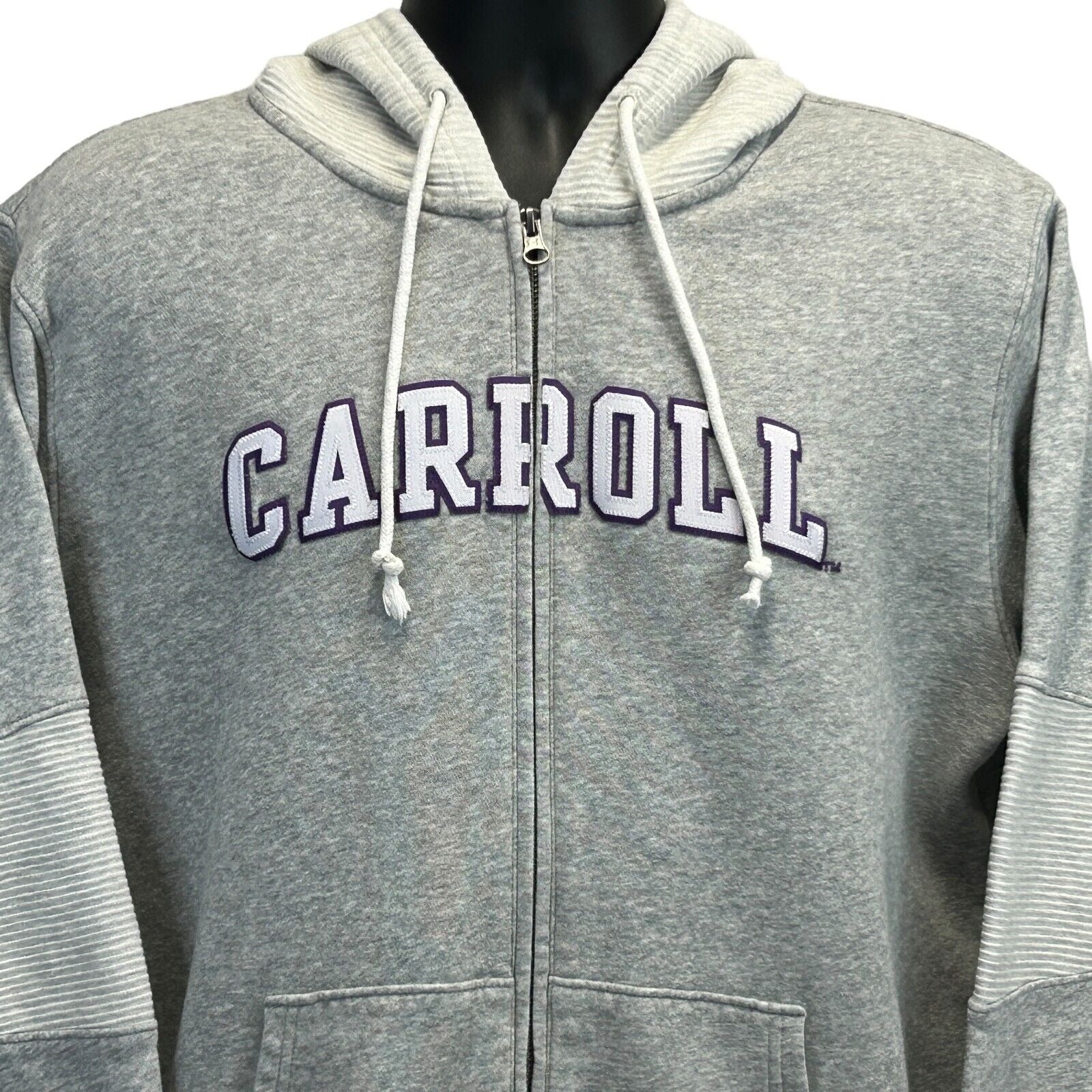 Grey Under Armour hoodie featuring Carroll College Saints logo, front view with zip closure and side pockets