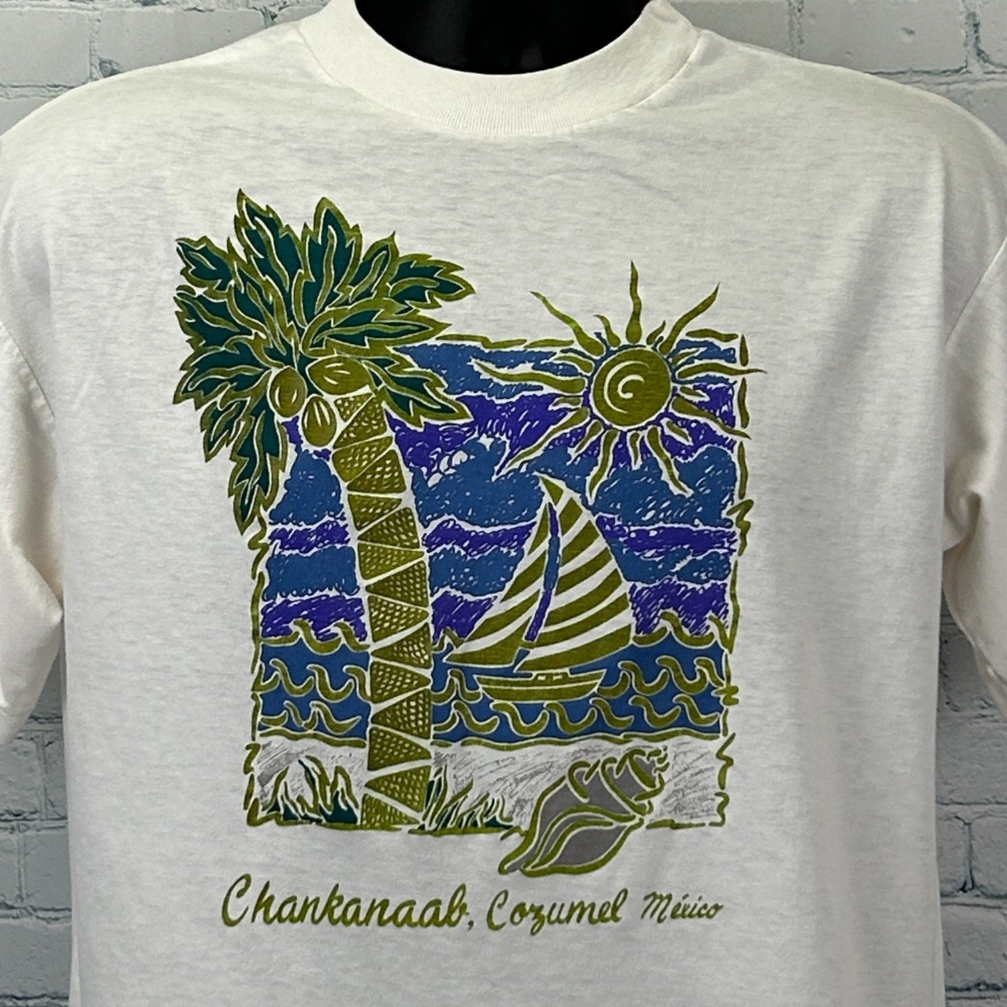 Front view of Vintage Cozumel T Shirt in cream featuring palm trees, sun, and sailboat design