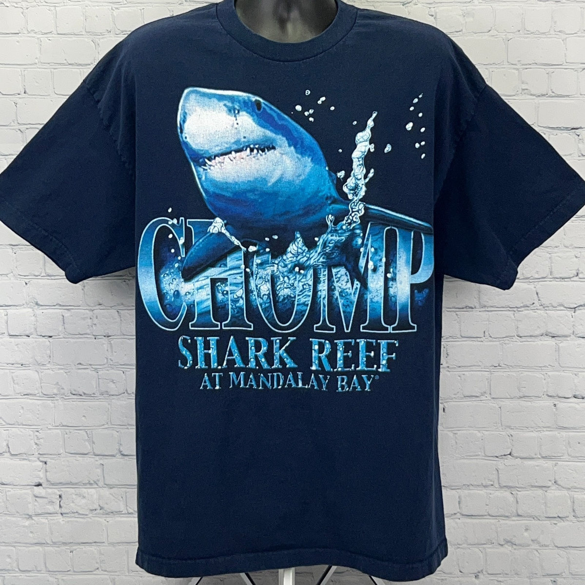 Navy blue Alstyle Apparel T-shirt featuring a shark graphic and 'Chomp Shark Reef' text on the front