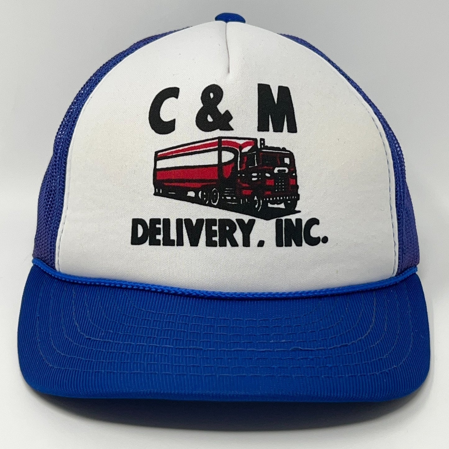 White and blue vintage trucker hat featuring C&M Delivery Inc logo with truck detail on the front