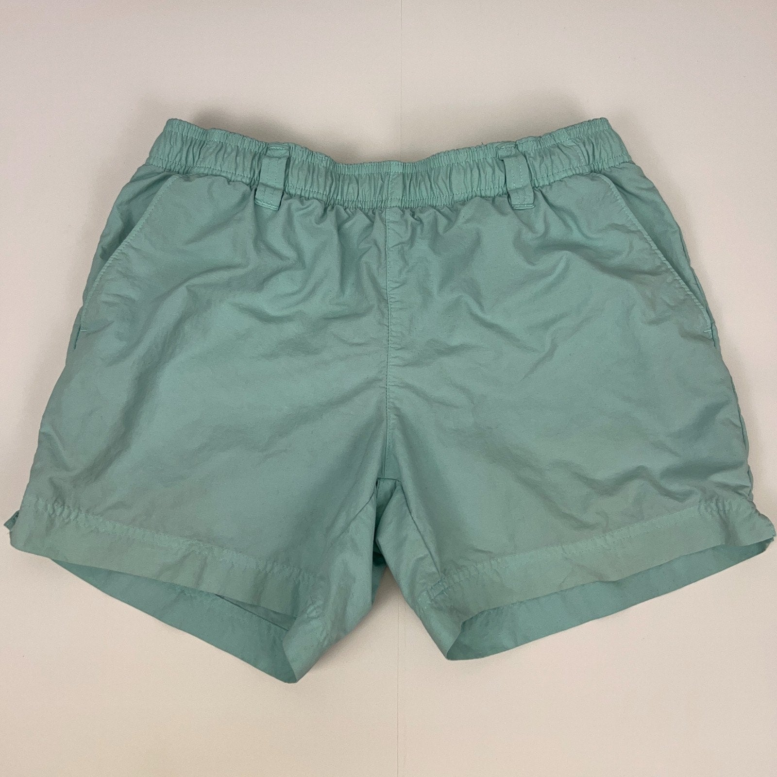 Columbia PFG light blue shorts with elastic waistband and side pockets, front view.