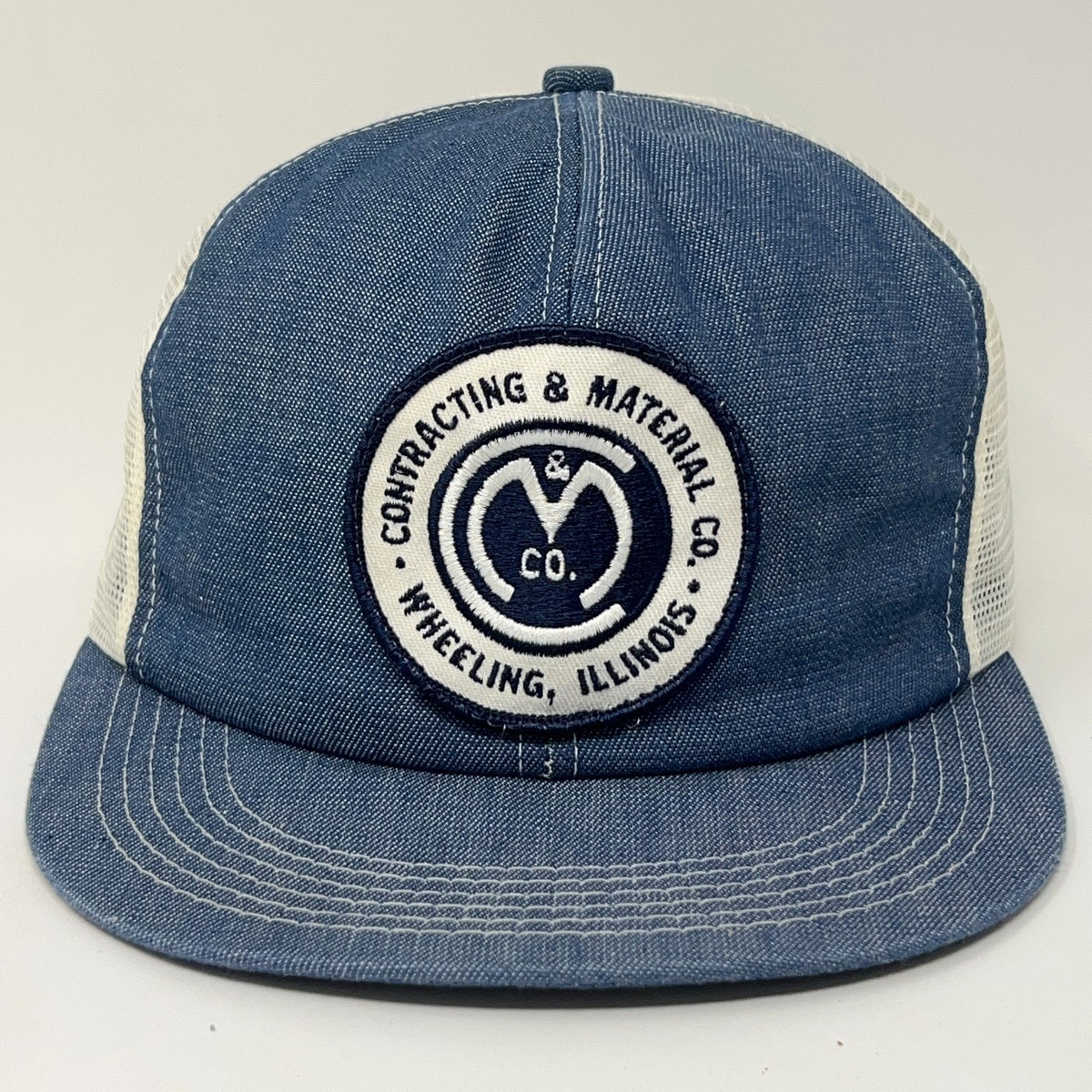 Vintage Contracting Material Co. trucker hat in denim blue with mesh back and logo patch