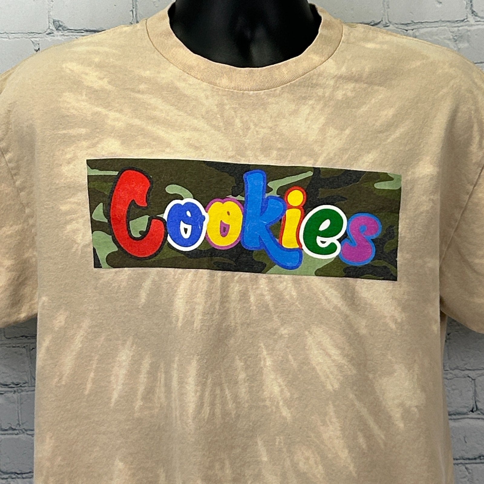 Beige Cookies Clothing T Shirt featuring multicolored logo box on the front