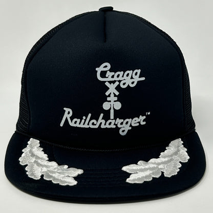 Front view of a Vintage Trucker Hat in black with white embroidered logos and leaf detail