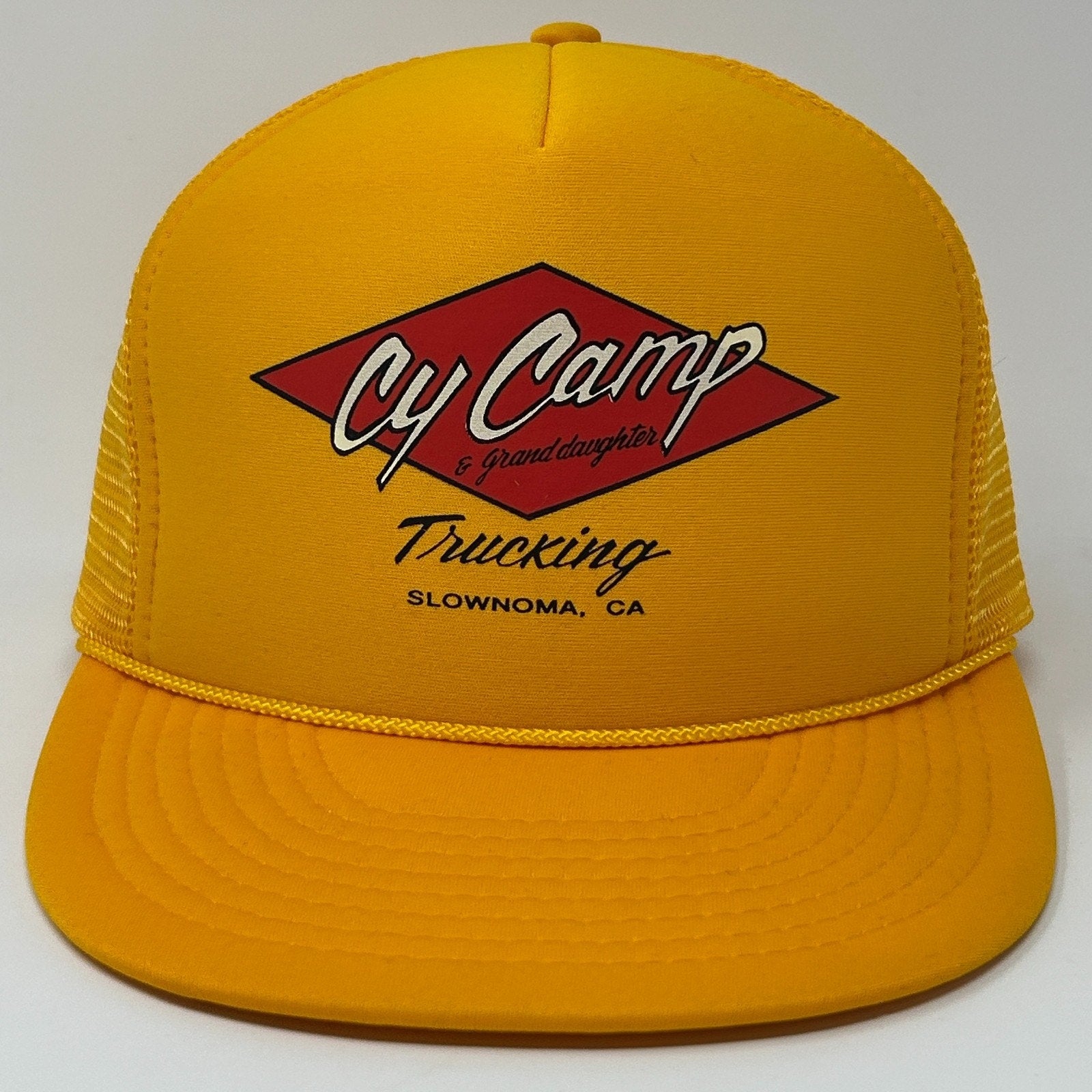 Vintage yellow Trucker Hat featuring Cy Camp Trucking logo on the front with mesh backing