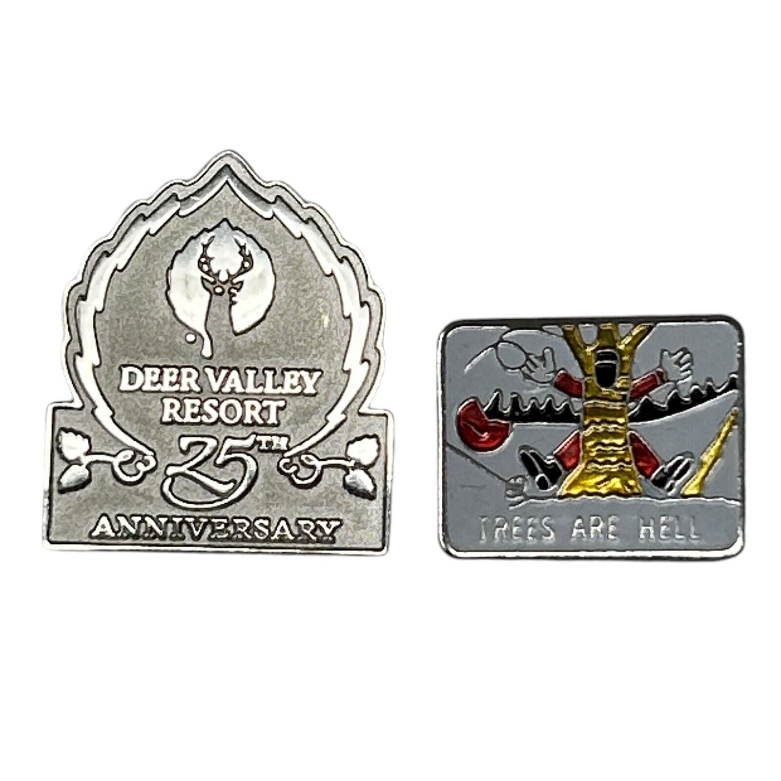 Two skiing-themed pins: a silver Deer Valley Resort 25th Anniversary pin and a colorful Trees Are Hell pin