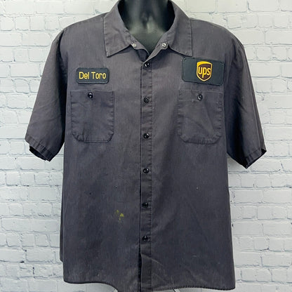 Black short-sleeve uniform shirt from Aramark with UPS logo and Del Toro embroidered name patch on front