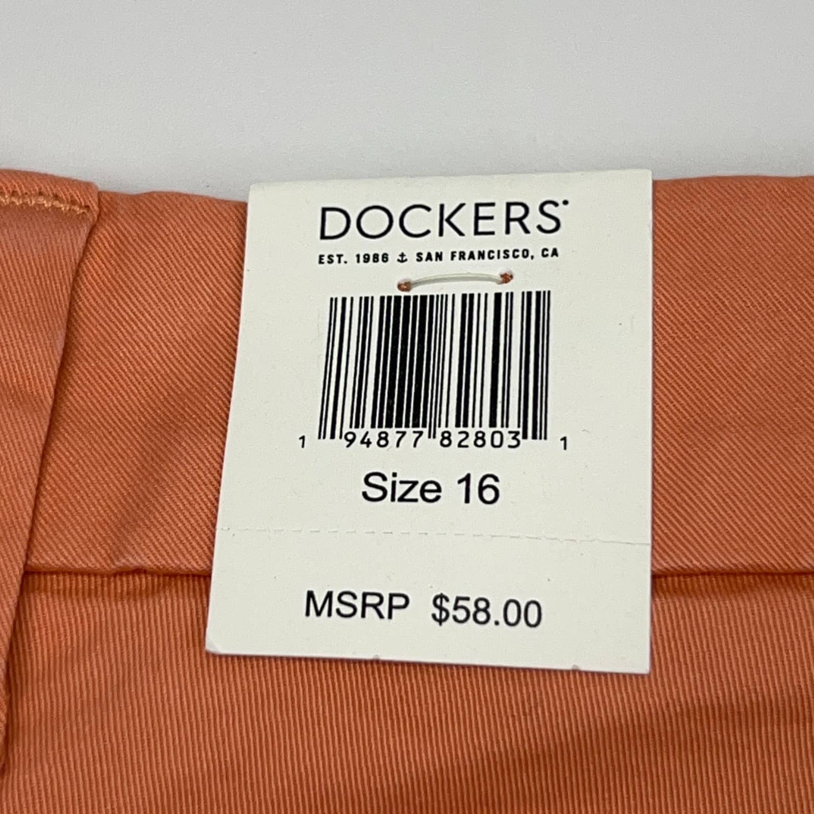 Dockers chino pants in coral, size 16, with retail tag visible, showcasing MSRP