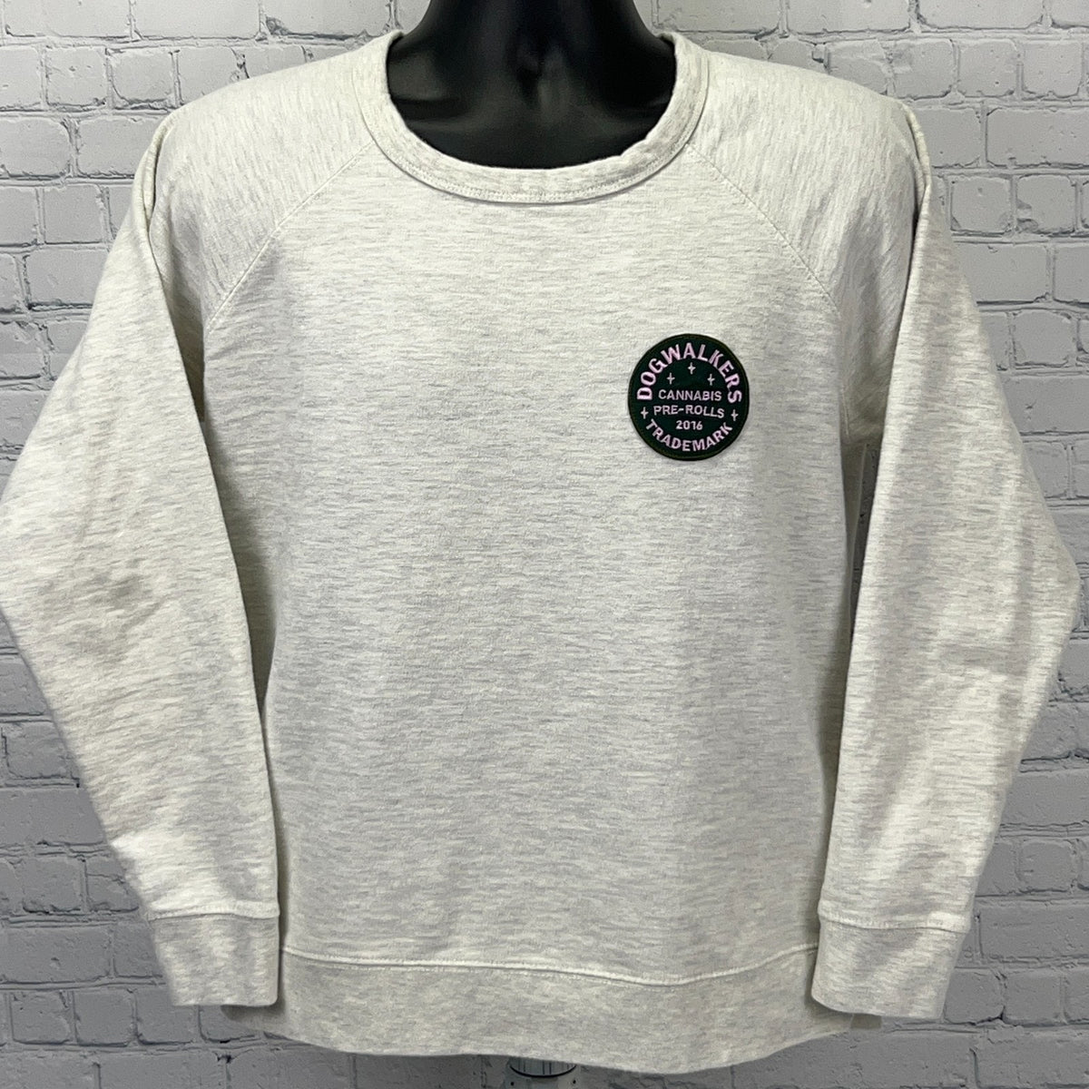 Light gray Dogwalkers Cannabis sweatshirt featuring a round logo on the front for a stylish, relaxed fit