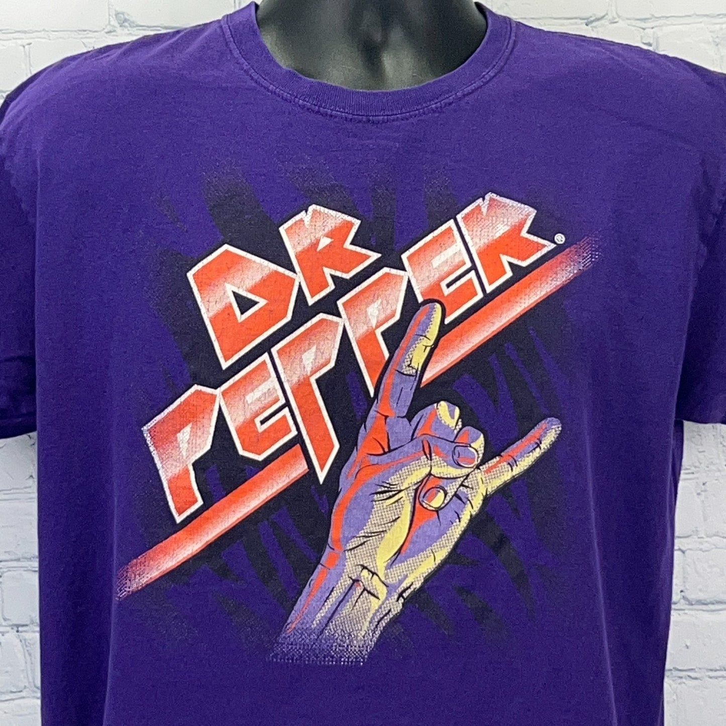 Purple Dr Pepper T-shirt featuring a graphic hand gesture and bold logo on the front