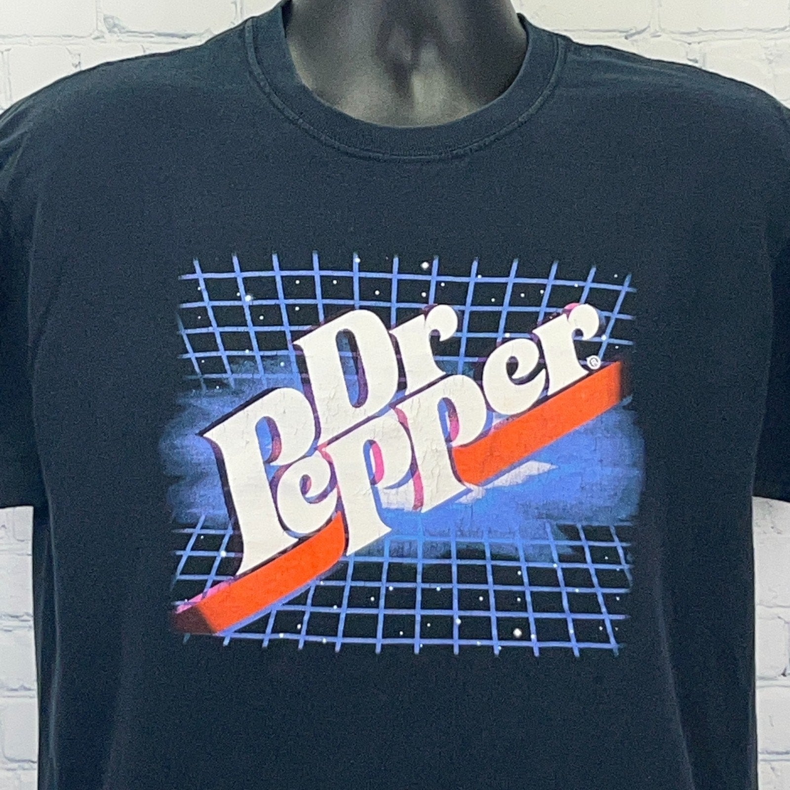Black Dr Pepper t-shirt featuring retro logo with grid pattern in front view