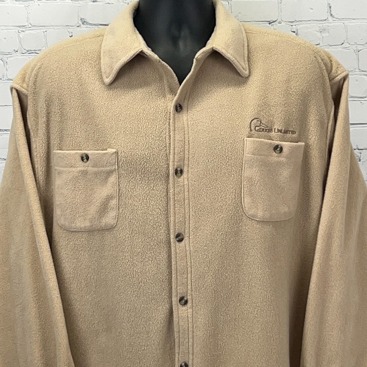 Tan Ducks Unlimited fleece shirt with button front, two chest pockets, and logo detail on the front