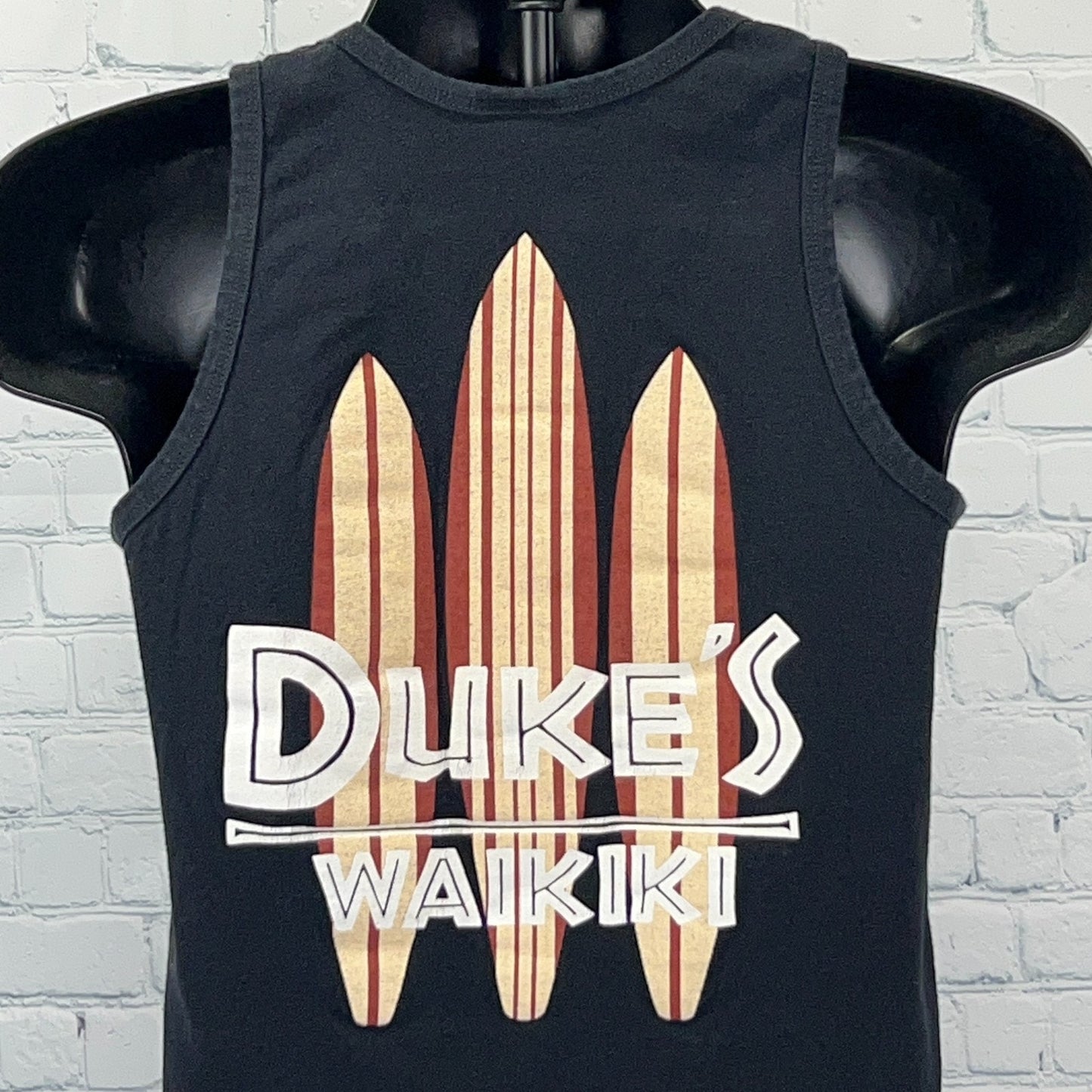Front view of Dukes Waikiki Tank Top in black with colorful surfboard graphic
