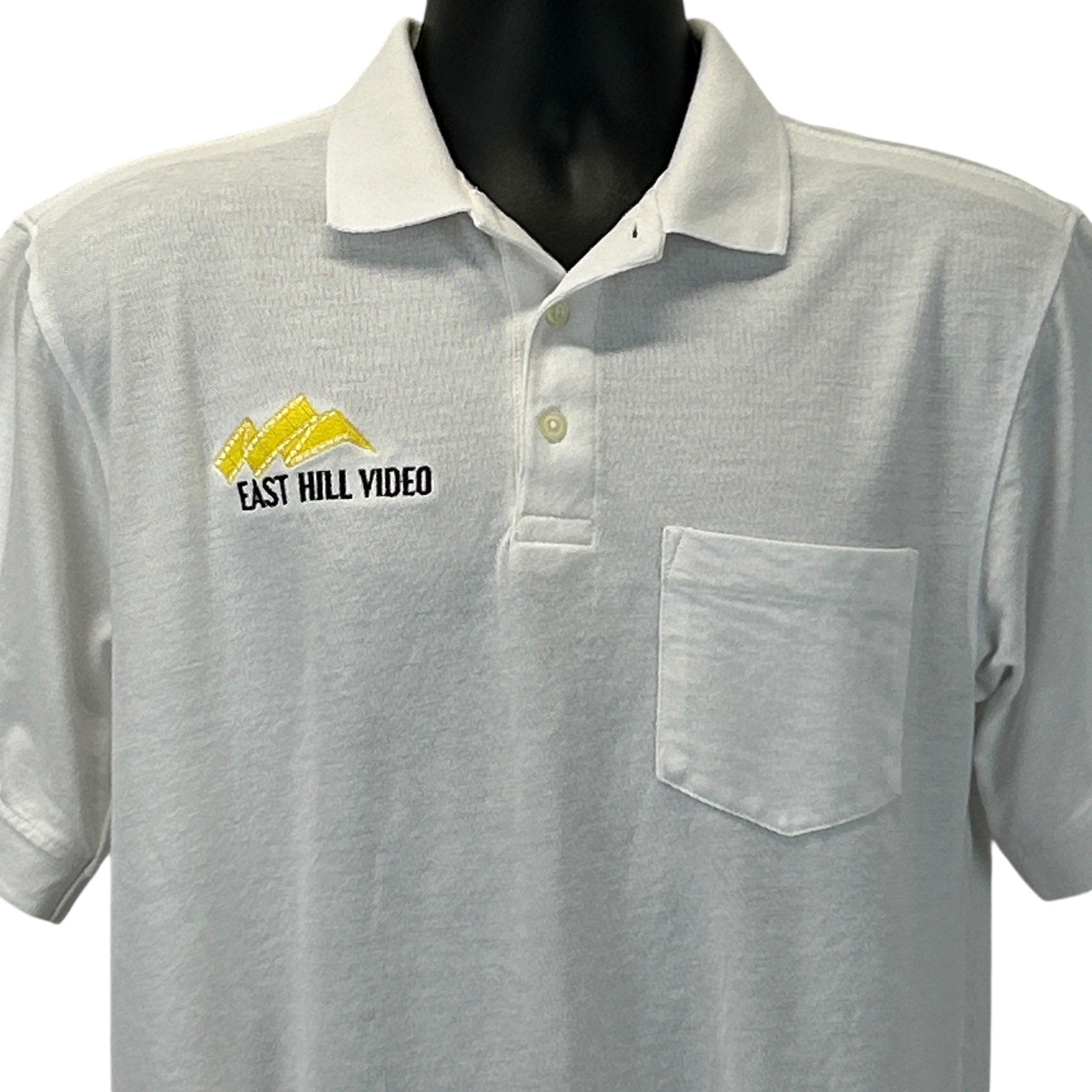 Light gray Harriton polo shirt with East Hill Video logo and front pocket detail