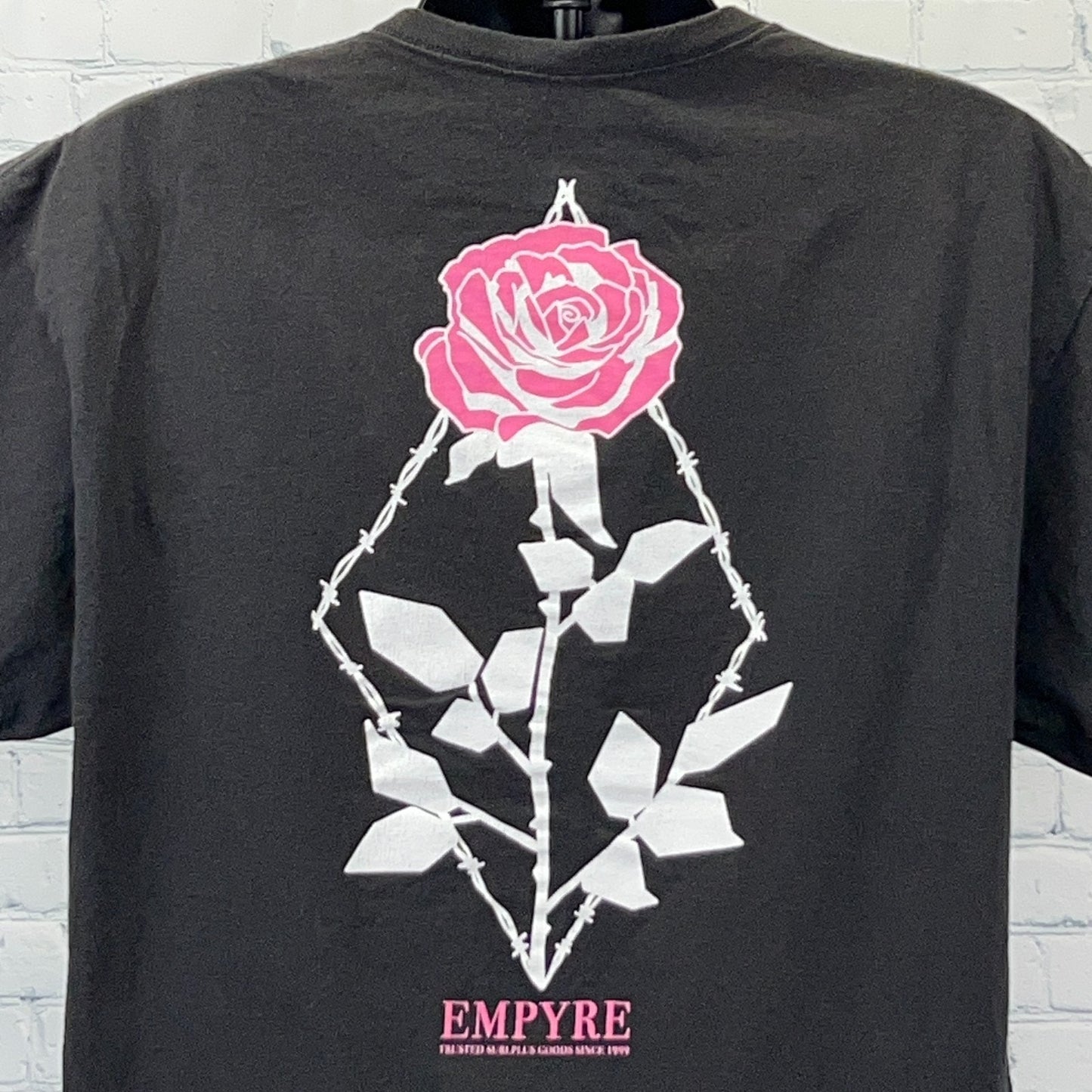Empyre T Shirt in black featuring a pink rose graphic on the back with thorn details