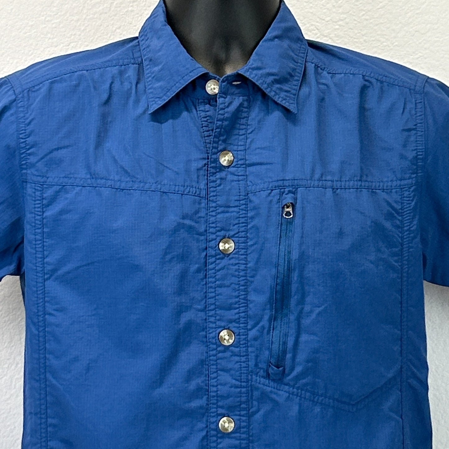 Front view of ExOfficio Shirt in blue, featuring a chest pocket and silver buttons