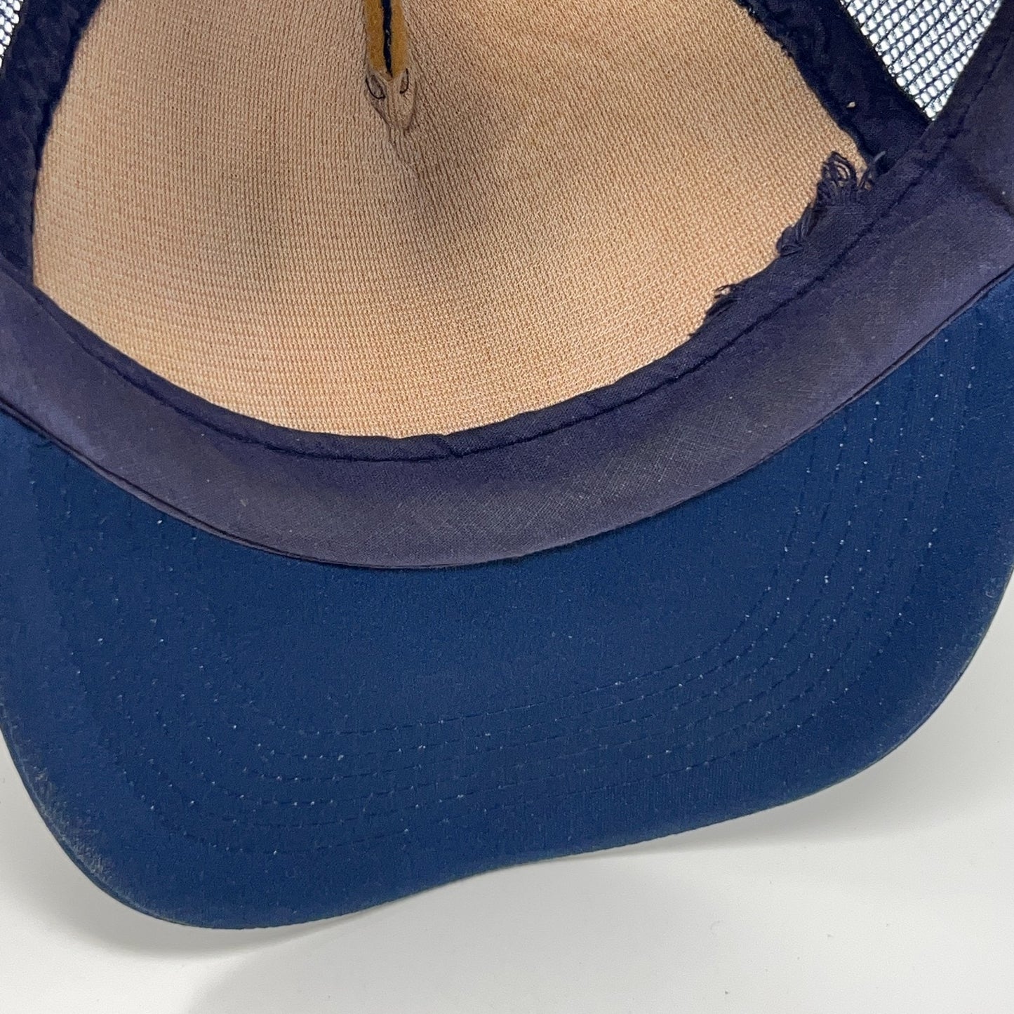 Vintage trucker cap hat in navy blue, showing interior view.