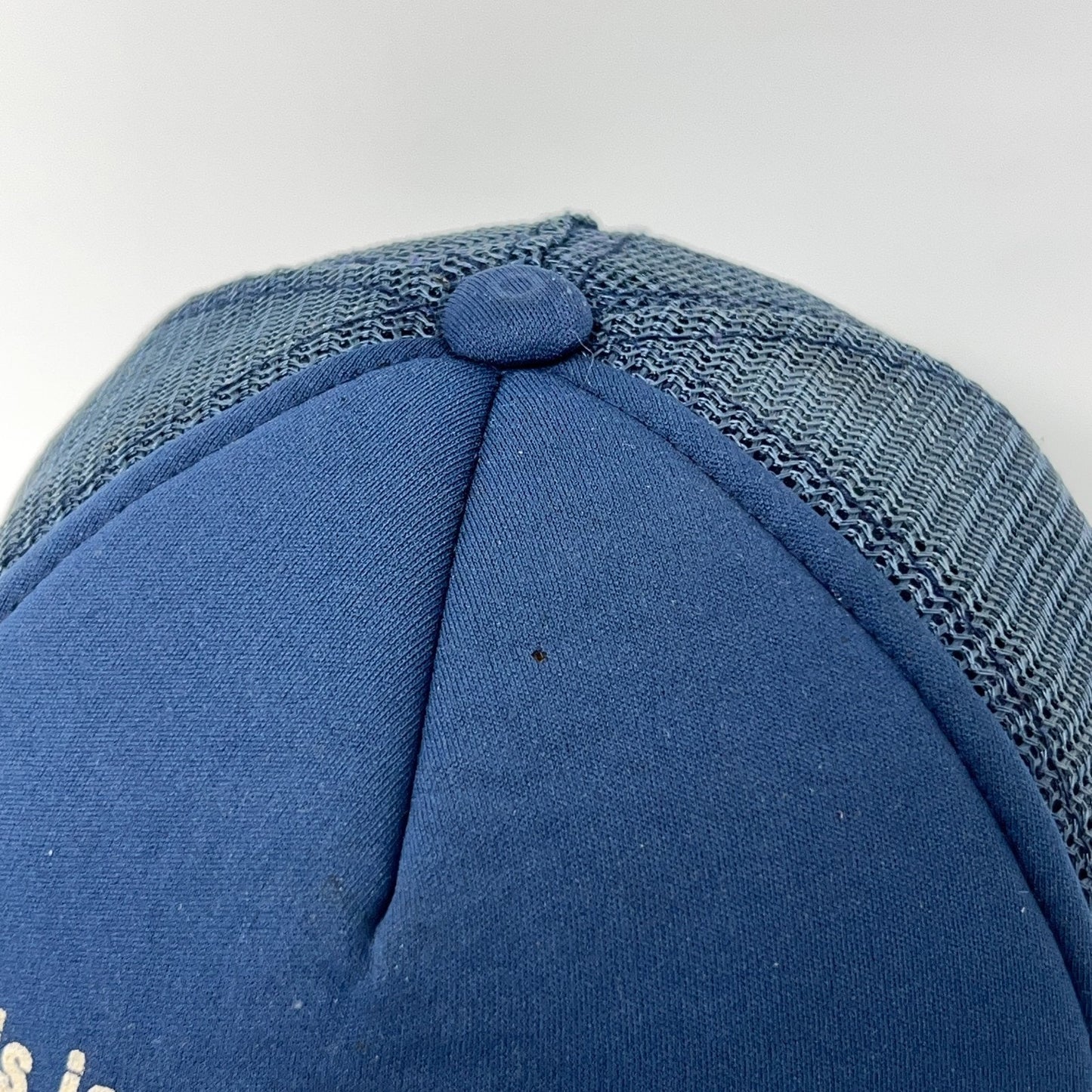 Vintage trucker cap hat in blue with mesh back and curved brim, showing top view