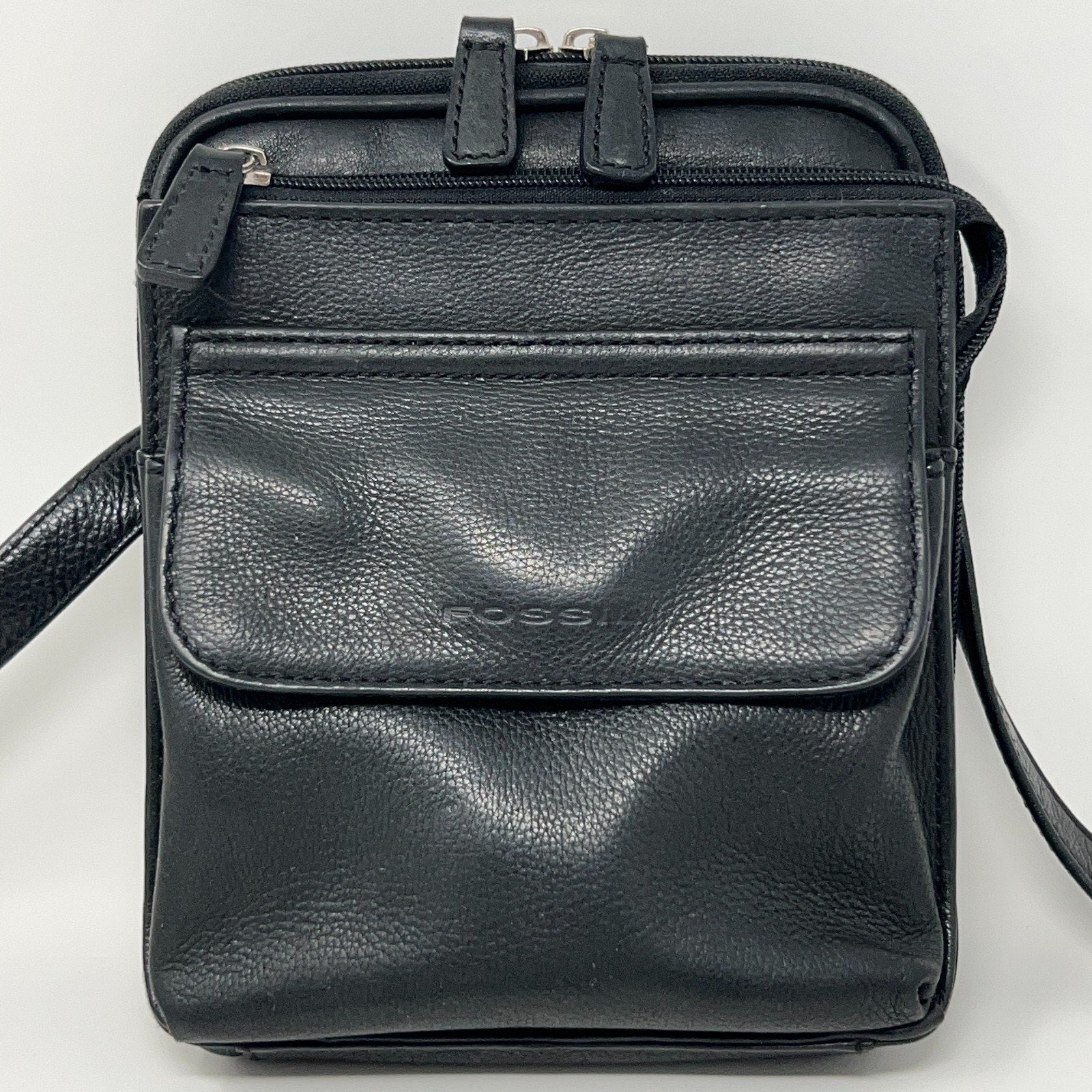 Fossil black leather crossbody bag with a front pocket and adjustable strap for convenience