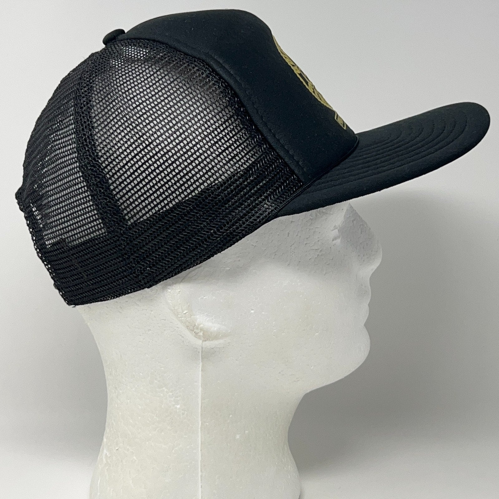 Vintage trucker hat in black, side view, featuring classic mesh design