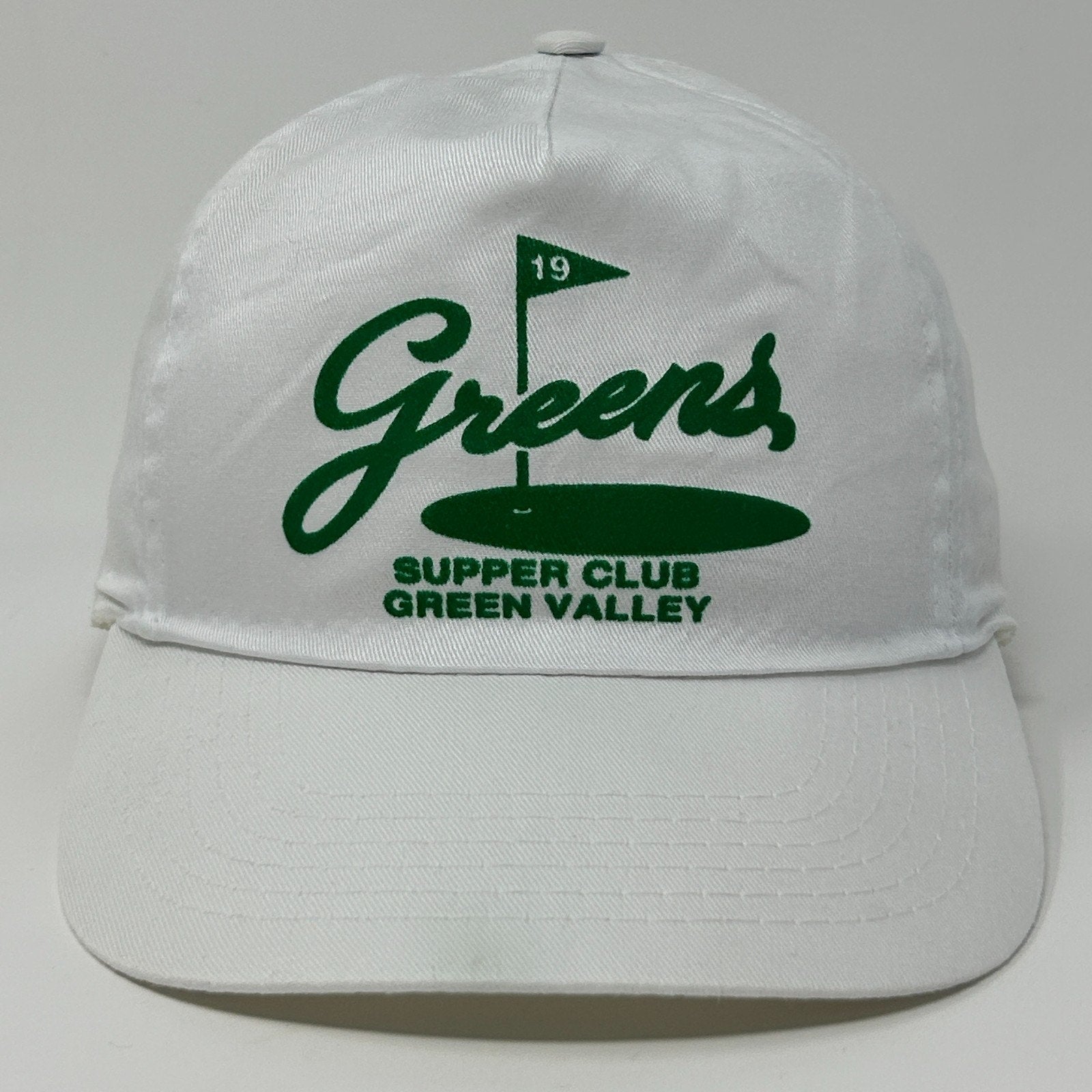 White vintage hat with Green Valley logo and green flag detail on the front